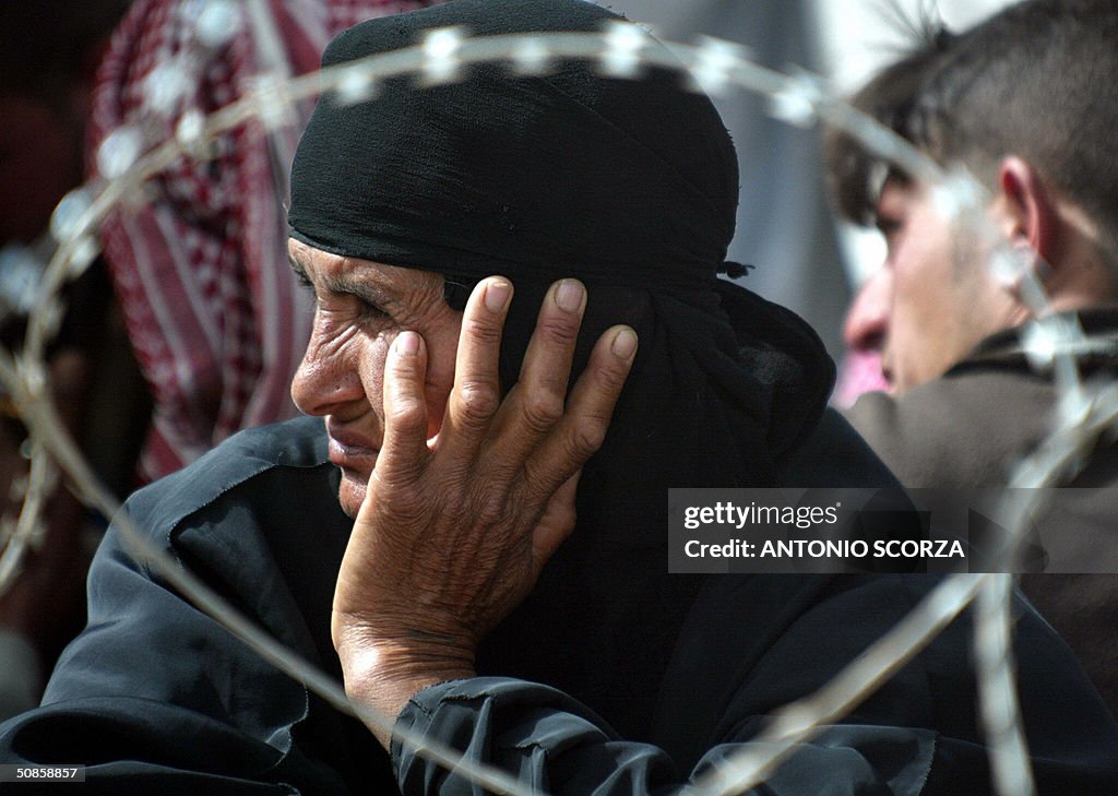An Iraqi woman looks on as she waits at