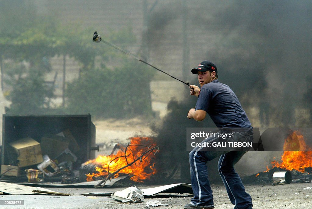 A Palestinian youth hurls stones at Isra