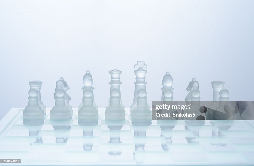 Glass chess on the transparent chessboard