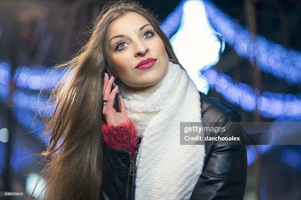 Giovane ragazza nella città notturno utilizzando smartphone