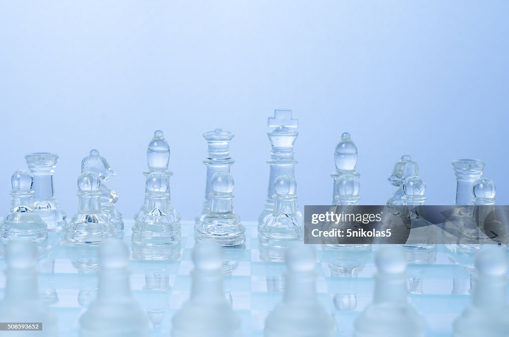 Glass chess on the transparent chessboard