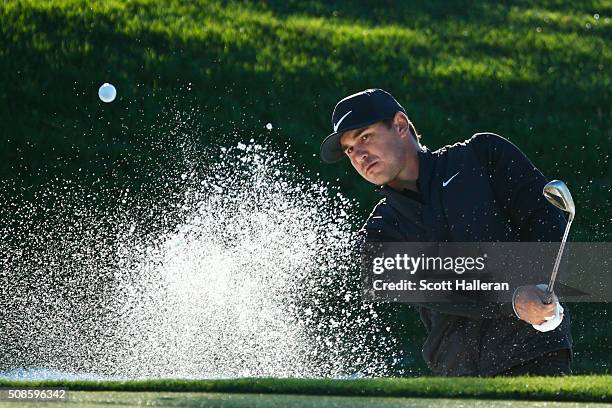 Brooks Koepka hits out of the bunker on the 12th hole during the second round of the Waste Management Phoenix Open at TPC Scottsdale on February 5,...