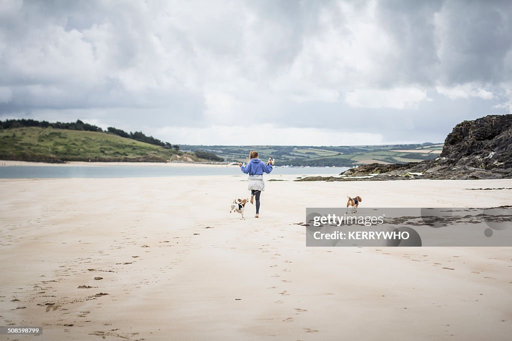 Teenage girl on the beach with dogs