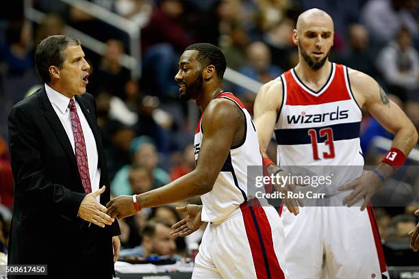 John Wall of the Washington Wizards celebrates with head coach Randy Wittman as Marcin Gortat looks on against the Philadelphia 76ers at Verizon...