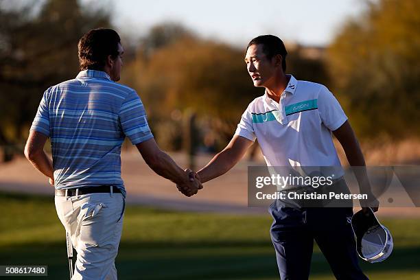 Danny Lee of New Zealand shakes hands with Keegan Bradley after finishing their round on the ninth hole during the second round of the Waste...