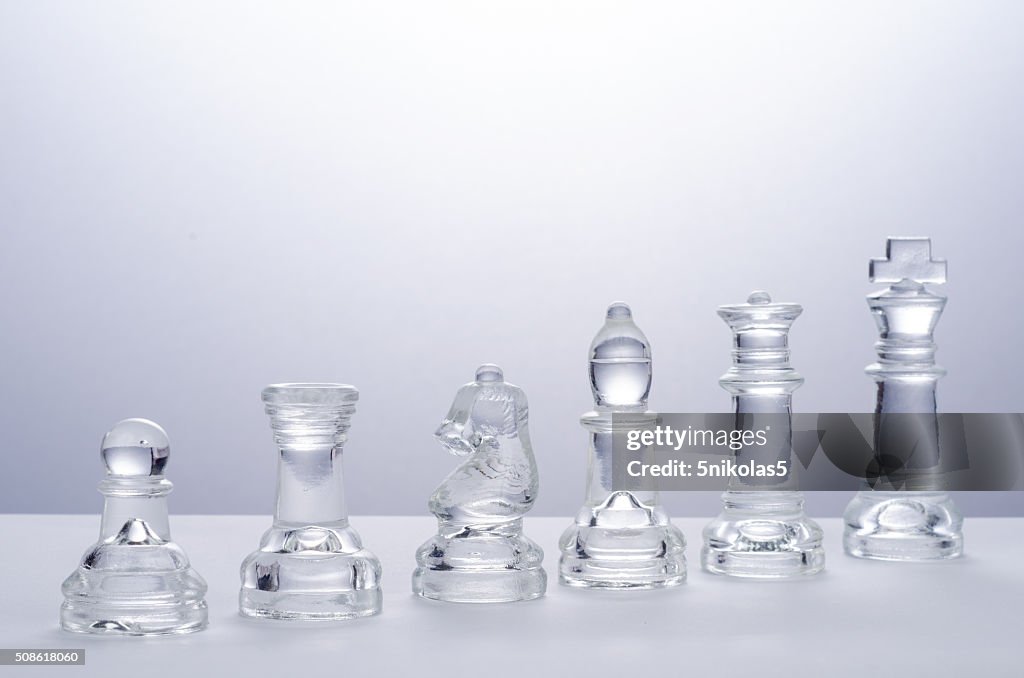 Glass chess on the transparent chessboard
