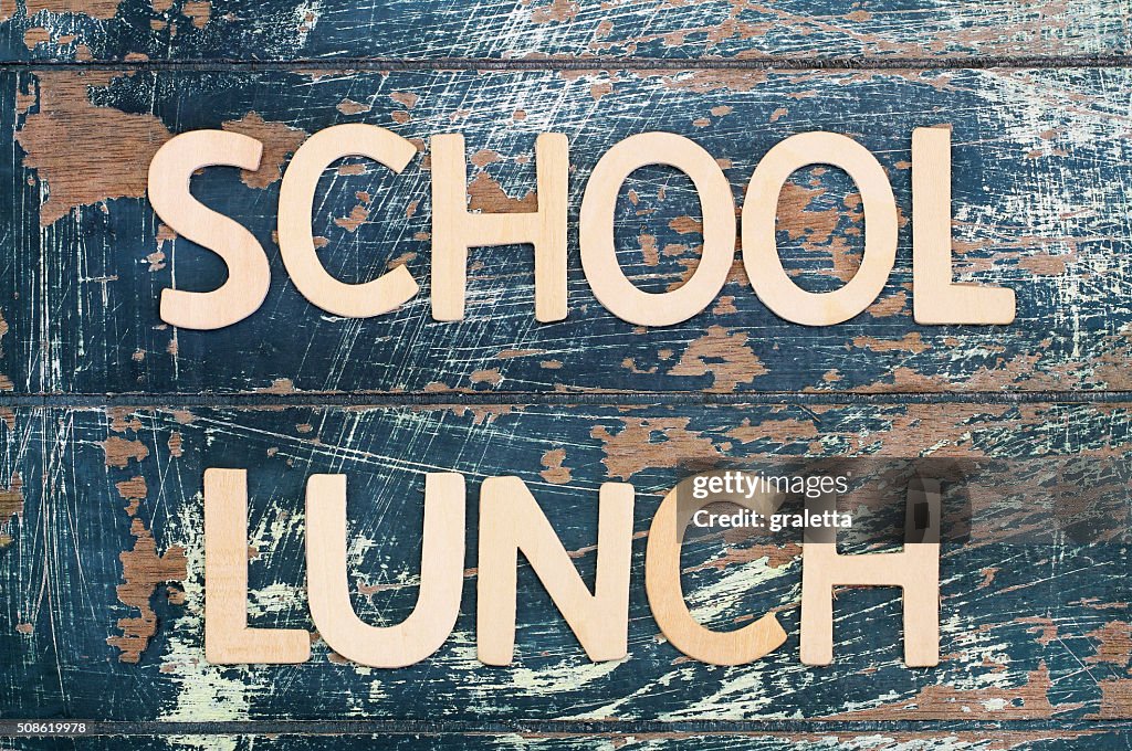 School lunch written with wooden surface on rustic surface