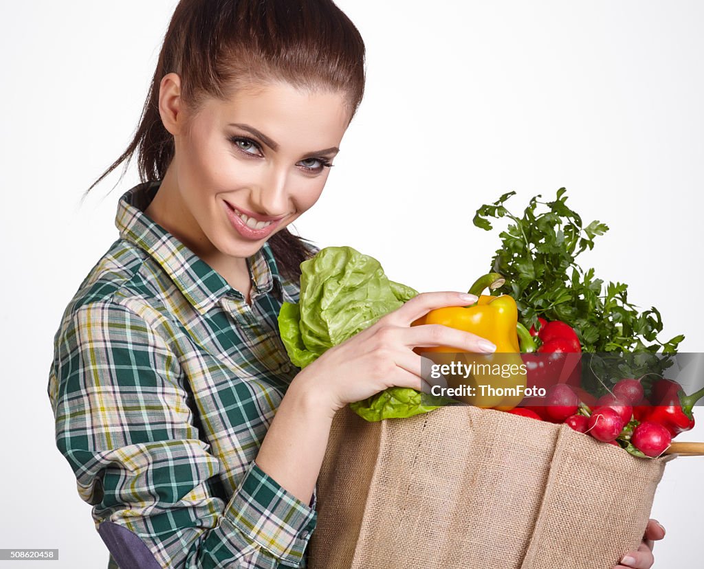 Young woman with vegetables and fruits in shopping bag