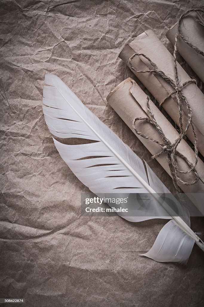 Heap of vintage paper rolls feather on crumpled wrapping sheet