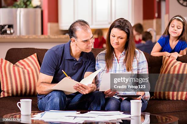 latin descent couple paying monthly bills at home. - middle class female stock pictures, royalty-free photos & images