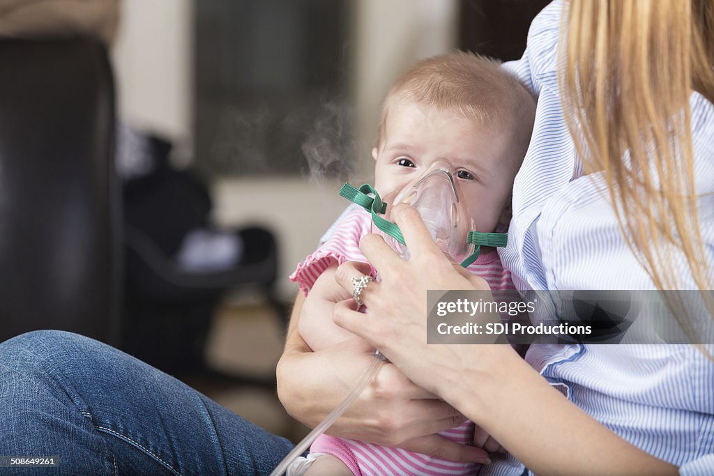 Mutter gibt nebulizer Atmen Behandlung von kranken Kind baby