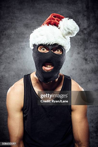 criminal with santa claus hat - christmas thief stock pictures, royalty-free photos & images