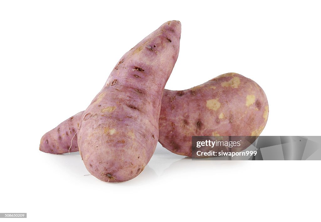 Whole purple yams photographed on a white background.