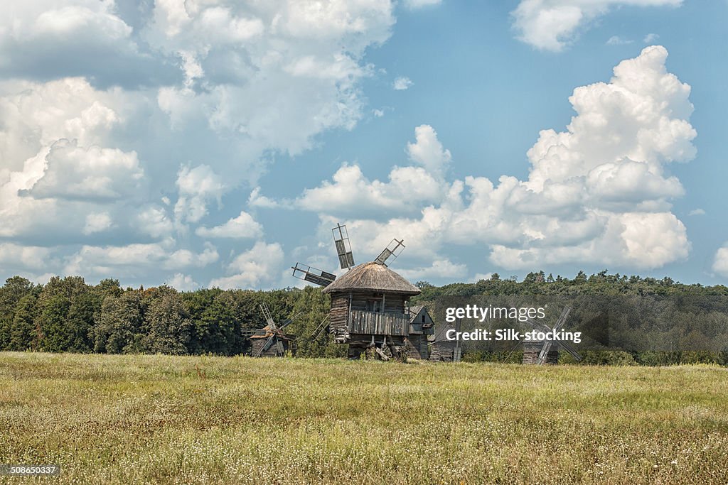 Old wooden windmills on the field.