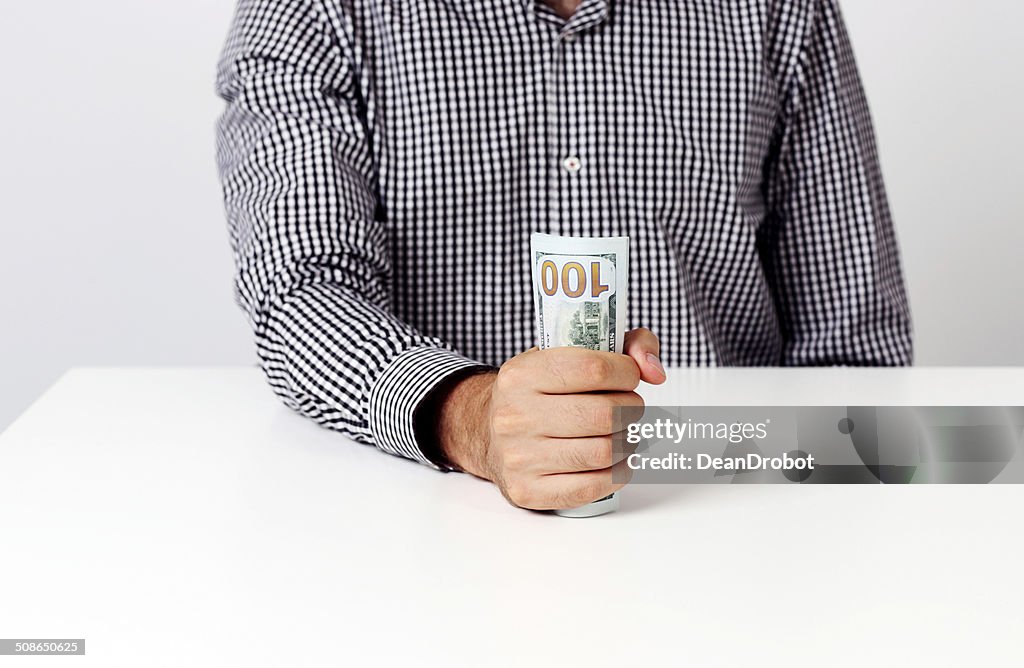Businessman holding banknotes at desk