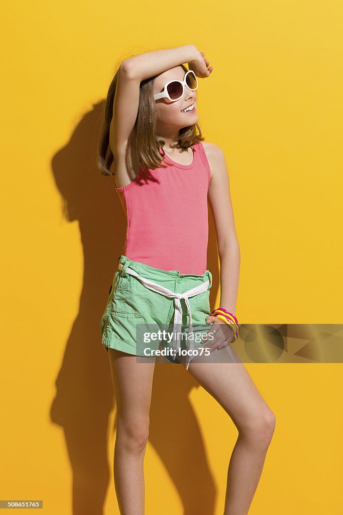 Smiling girl posing in the sunglasses and looking away