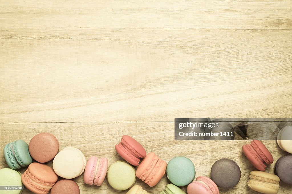 Colorful macaroons on wooden background , top view