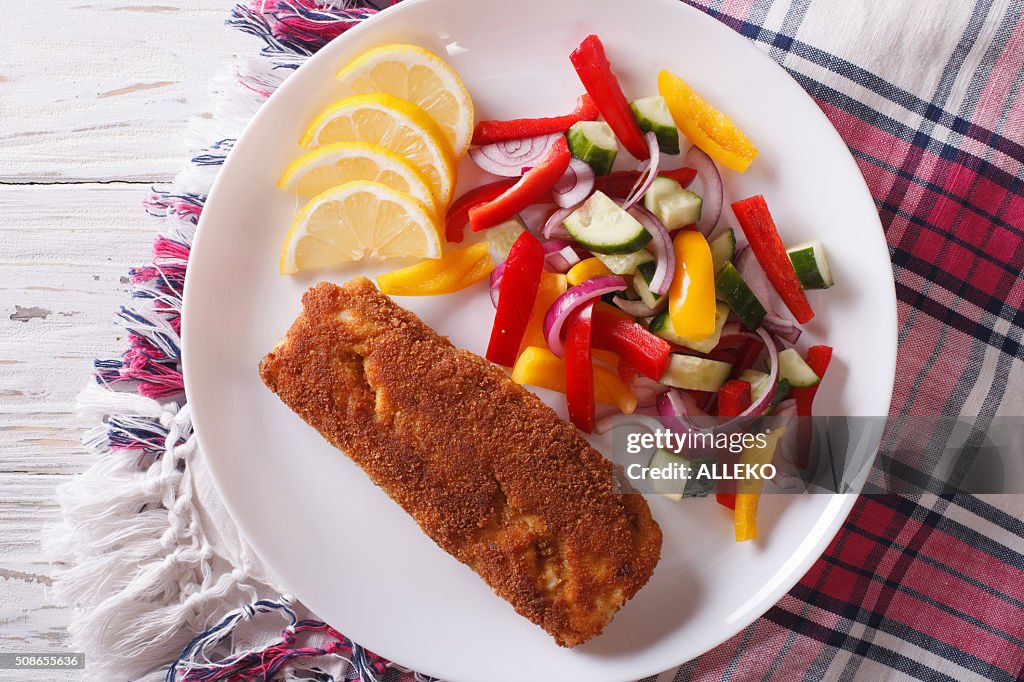 Fried fish fillet with fresh vegetables closeup. horizontal top