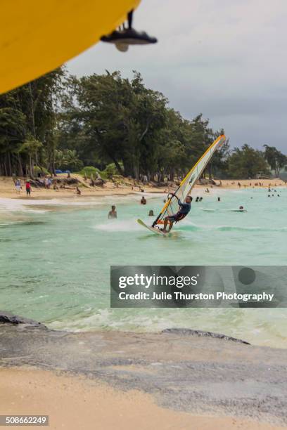 Beach Goers in Swimsuits Enjoy Watching Recreation Kiteboarding, Windsurfers and Kayakers in the Teal Colored Pacific Ocean at the Vacation Travel...