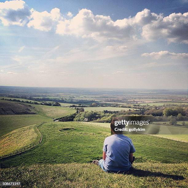 boy on hill lost in thought - boy sitting stock pictures, royalty-free photos & images