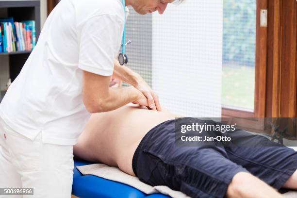 doctor checking abdomen of mature patient - appendicitis 個照片及圖片檔