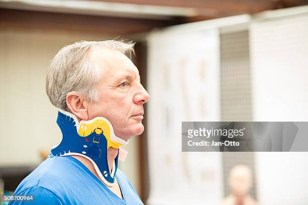 mature patient wearing a spine collar - menselijke nek stockfoto's en -beelden