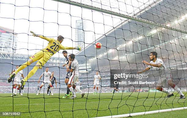 Goalkeeper Andrew Redmayne of the Wanderers dives but can't stop the shot of Besart Berisha of the Victory from scoring the first goal during the...