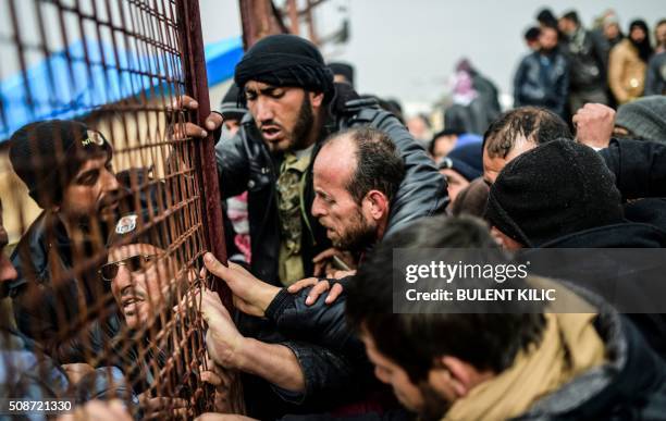 Refugees push each other as they wait for tents as Syrians fleeing the northern embattled city of Aleppo wait on February 6, 2016 in Bab al-Salama,...