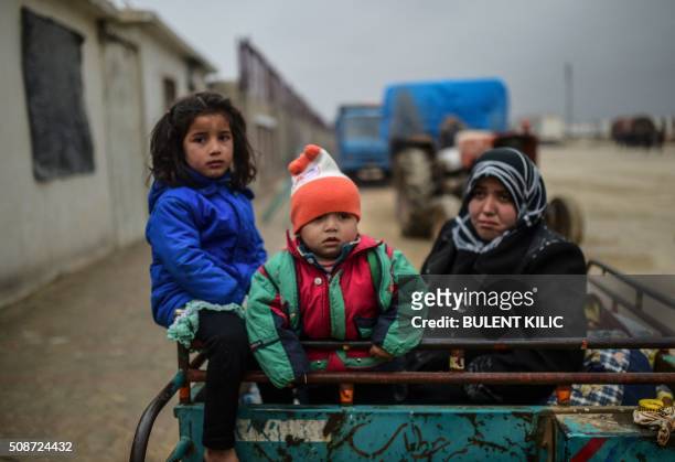 Refugee children arrive a the Turkish border crossing gate as Syrians fleeing the northern embattled city of Aleppo wait on February 6, 2016 in Bab...