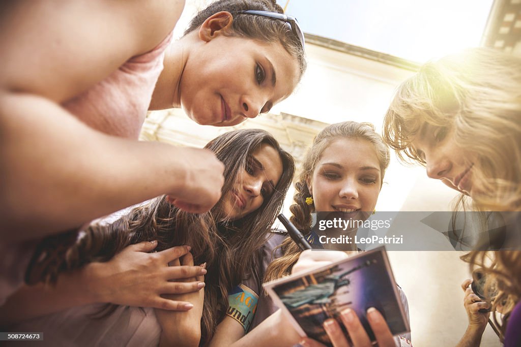 Teenagers writing on a postcard