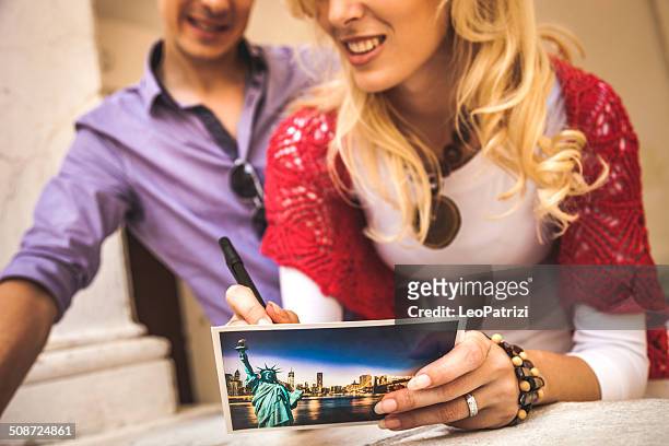 couple writing on a postcard - postcards stock pictures, royalty-free photos & images