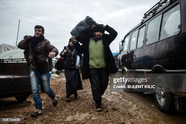 Refugees arrive at the Turkish border crossing gate as Syrians fleeing the northern embattled city of Aleppo wait on February 6, 2016 in Bab...