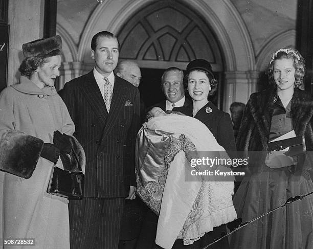 Queen Elizabeth II holding the baby after the christening of the son of Lord Porchester and Lady Porchester , at St Paul's, Knightsbridge, London,...