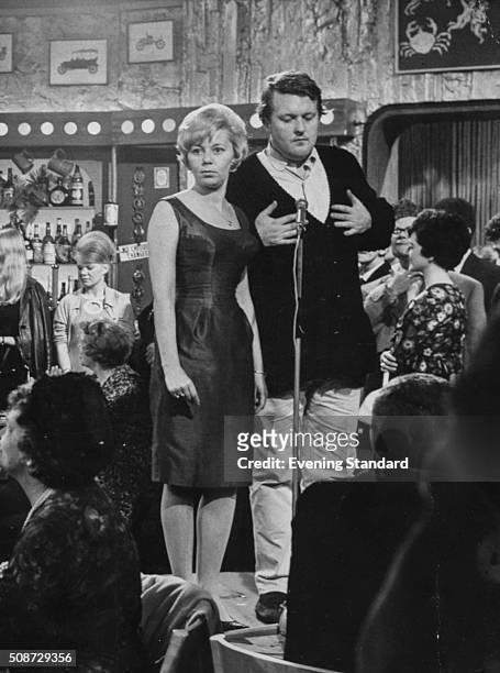 Actors Jill Browne and William Rushton, stars of the television show 'New Stars and Garters', singin on stage, 1965.