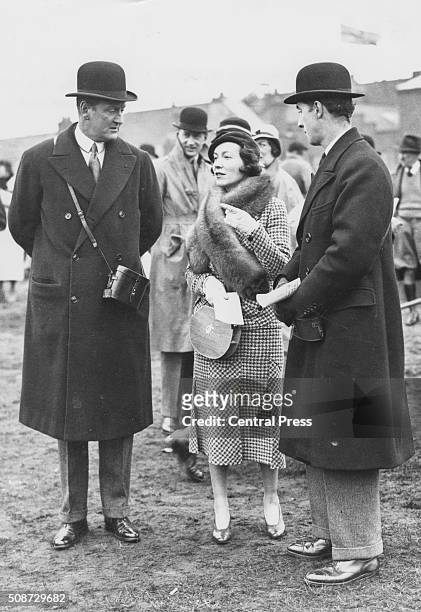 Horse trainer Captain Cecil Boyd-Rochford and dancer Adele Astaire, the wife of Lord Charles Cavendish, having a discussion in the paddock at Aintree...