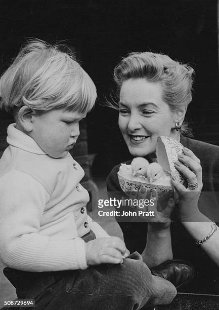 Actress Patricia Roc presenting her young don Micky with two chicks in a toy egg as an Easter gift, at her sisters home in Maidenhead, England, circa...