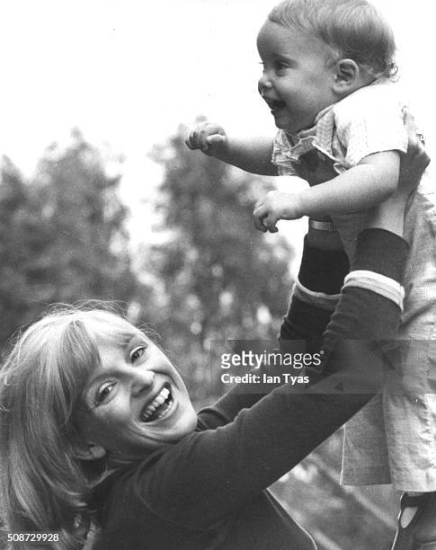 Actress Jane Rossington smiling as she lifts her baby daughter Sorrel in the air, they play mother and daughter characters in the British soap opera...