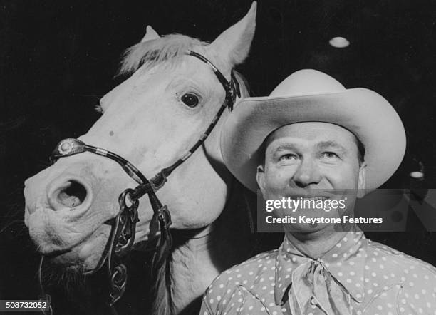Portrait of American country music singer Tex Ritter and his horse, circa 1955.