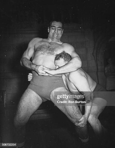 Boxer Primo Carnera holding wrestler Milo Steinborn in a headlock during training at the Imperial Gymnasium in London, October 18th 1951.