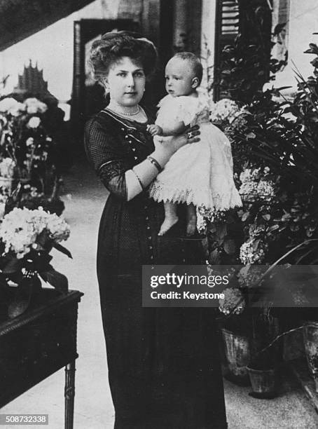 Portrait of Queen Victoria Eugenie of Spain holding her baby daughter Princess Beatriz, 1909.