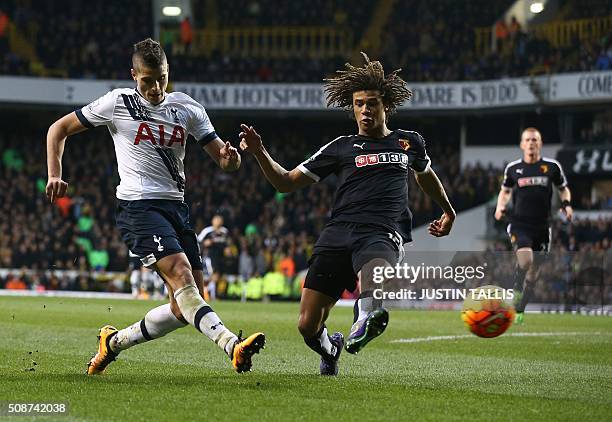 Tottenham Hotspur's Argentinian midfielder Erik Lamela shoots past Watford's Dutch defender Nathan Ake during the English Premier League football...