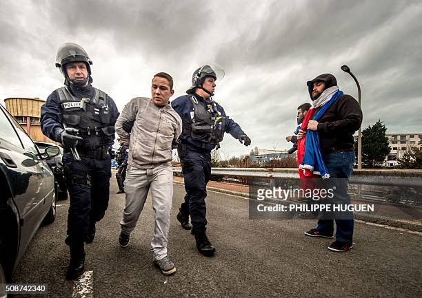 Policemen arrests a supporter of the Pegida movement during a demonstration in Calais, northern France on February 6, 2016. Anti-migrant protesters...