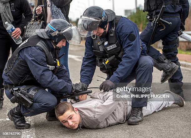 French riot police arrest a supporter of the Pegida movement during a banned demonstration in Calais, northern France, on February 6, 2016. Around 20...