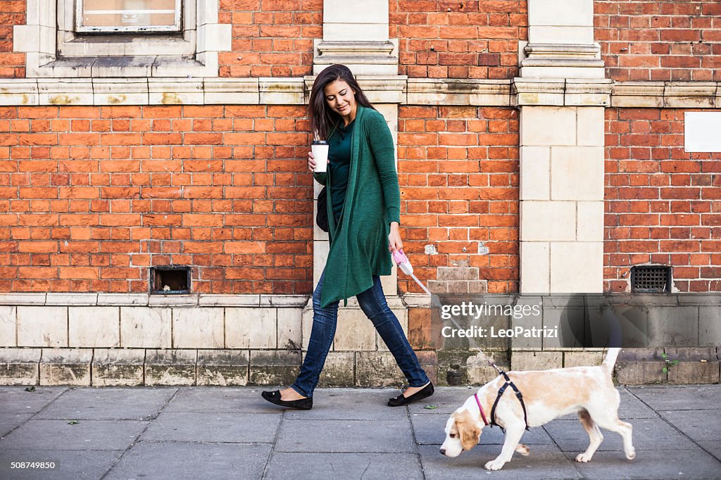 Woman walking with dog in early Sunday morning in London