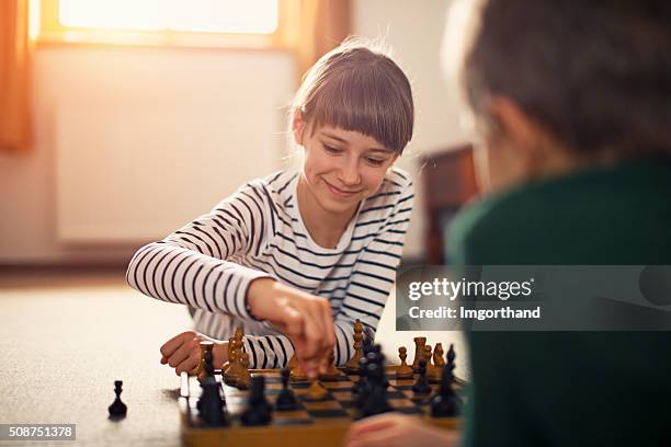 little girl playing chess with her brother - kids playing chess stock pictures, royalty-free photos & images