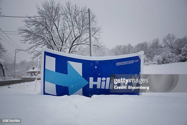 Campaign sign for Senator Hillary Clinton sits covered in snow in Exeter, New Hampshire, U.S., on Friday, Feb. 5, 2016. Democratic Party officials in...
