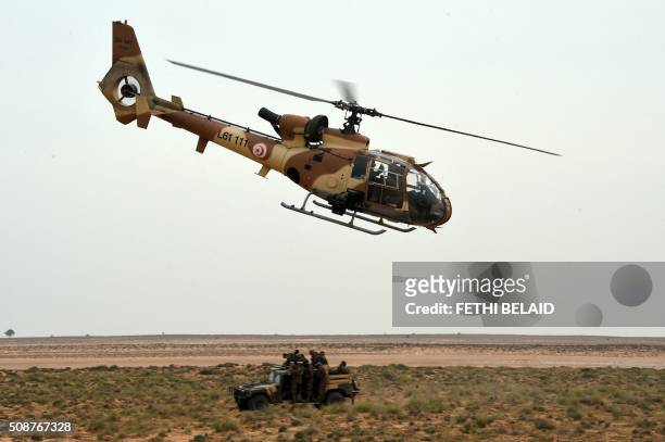 Tunisian army special forces take part in a military exercise along the Libyan border on February 6 near the Ras Jedir crossing point. - The...