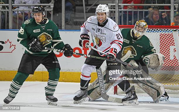 Jonah Gadjovich of the Owen Sound Attack looks for a shot to tip between Victor Mete and Brendan Burke of the London Knights during an OHL game at...