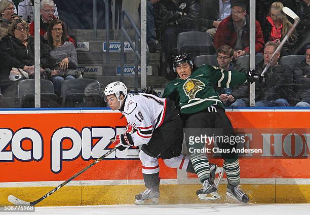 Markus Phillips of the Owen Sound Attack battles against Kole Sherwood of the London Knights during an OHL game at Budweiser Gardens on February 5,...