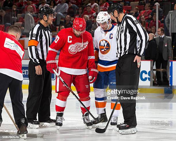 Captains Henrik Zetterberg of the Detroit Red Wings and John Tavares of the New York Islanders inspect the ice with referee Jean Hebert and linesman...